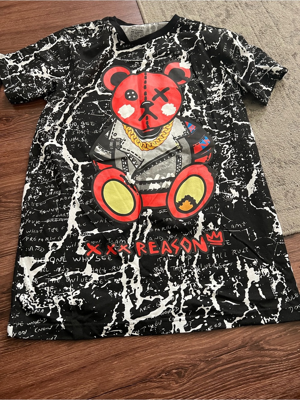 Reason Black Tee with Red Bear Graphic and Yellow Accents
